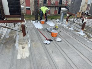 Team member performing metal roofing repairs