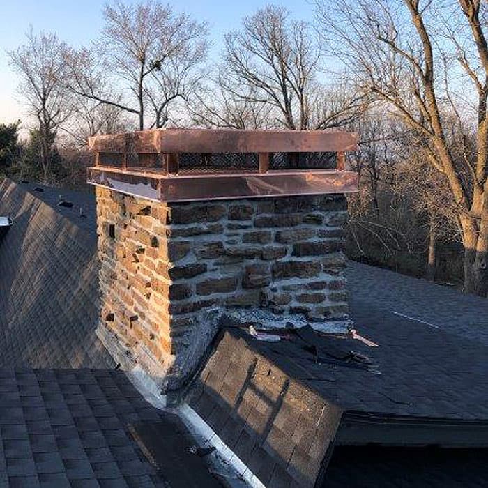 Damaged and old flashing being removed from a chimney